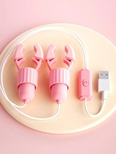 Электрический вибрирующий зажим для сосков «Электроискра» с USB-зарядкой — регулируемый БДСМ стимулятор, светло-розовый - Электрический зажим для сосков с вибрацией, расположенный на руке.